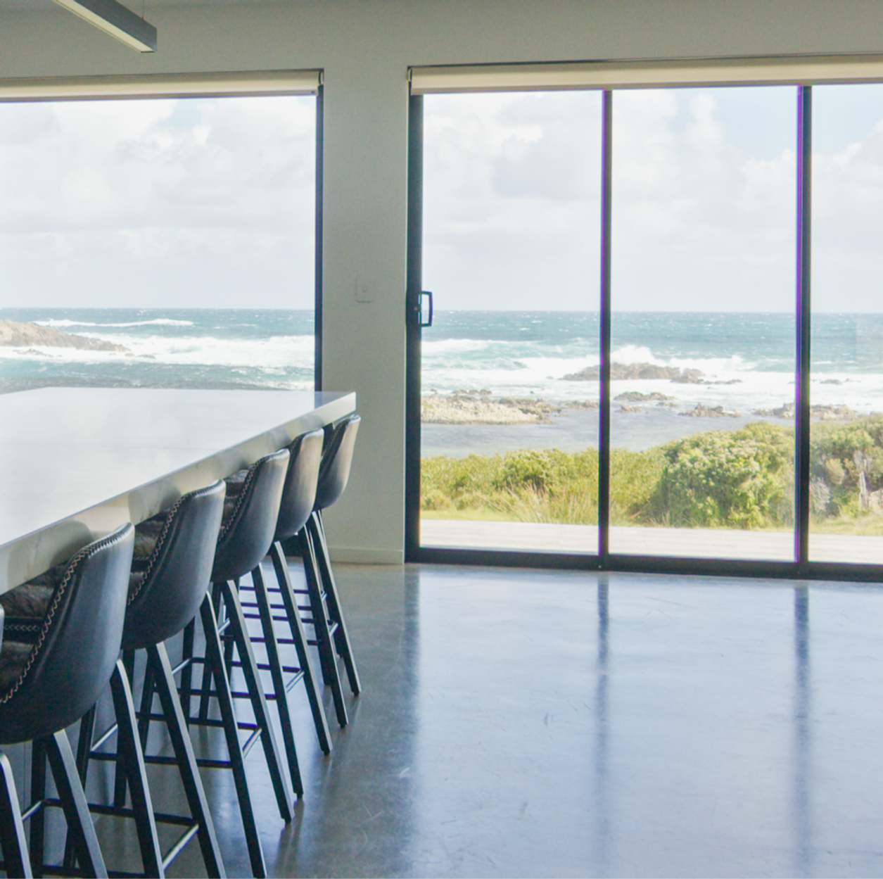 Kitchen and dining with floor-to-ceiling views of the King Island coastline